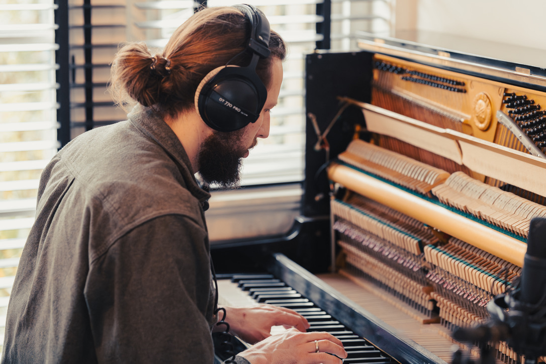 Zeb van Drie speelt piano met een studiokoptelefoon op